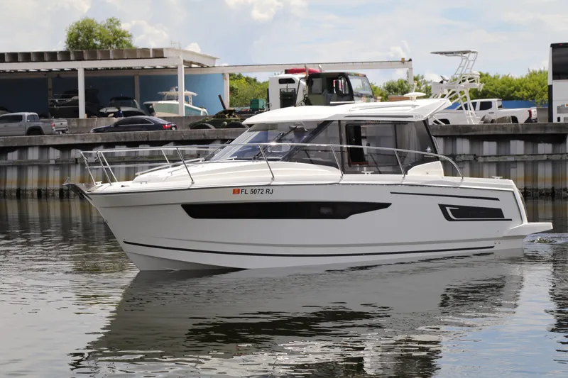 Slide: The Image of 2017 Jeanneau NC 895 boat on calm water near a marina. - 15