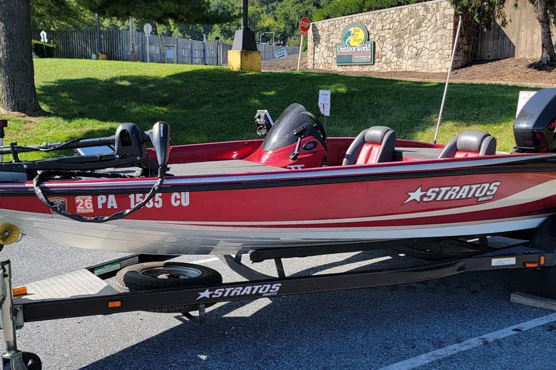 Slide: The Image of 2004 Stratos 275 Pro XL boat on trailer, parked outdoors near Bass Pro Shops. - 13