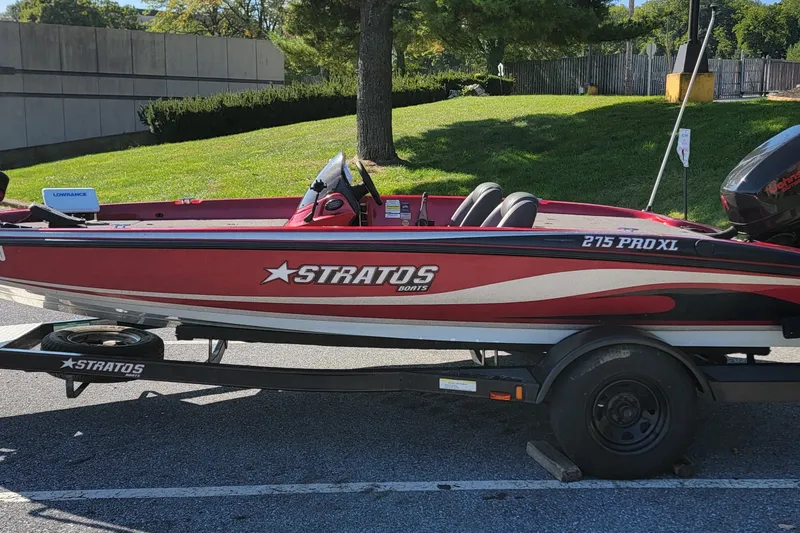 Slide: The Image of 2004 Stratos 275 Pro XL boat on trailer, parked outdoors in sunny setting. - 14
