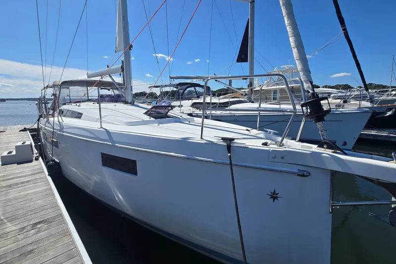 The Image of 2020 Jeanneau Sun Odyssey 410 sailboat docked at marina under clear blue sky. - 1