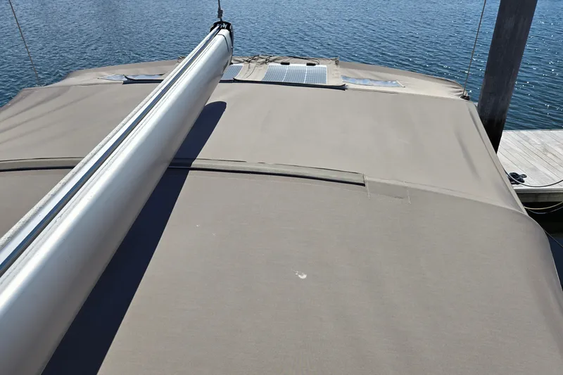 Slide: The Image of Jeanneau Sun Odyssey 410 sailboat deck with boom, docked by the water. - 25