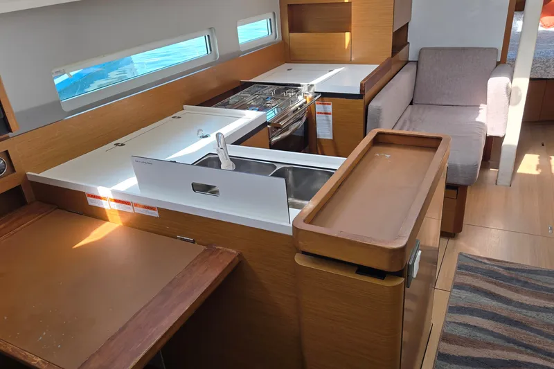 Slide: The Image of Interior of 2020 Jeanneau Sun Odyssey 410 yacht, featuring modern kitchen and seating area. - 27