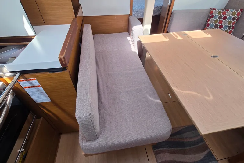 Slide: The Image of Interior of 2020 Jeanneau Sun Odyssey 410, featuring a cozy seating area and dining table. - 38