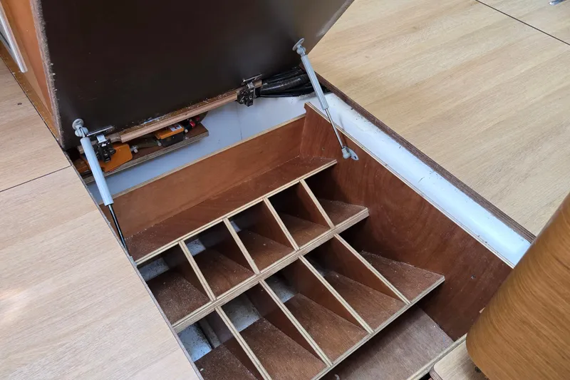 Slide: The Image of Open storage compartment in 2020 Jeanneau Sun Odyssey 410 sailboat, showcasing wooden interior structure. - 51