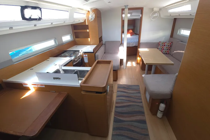 Slide: The Image of Interior of 2020 Jeanneau Sun Odyssey 410 yacht, featuring modern kitchen and cozy seating area. - 28