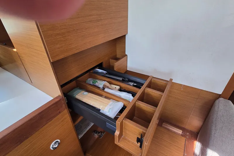 Slide: The Image of Interior view of Jeanneau Sun Odyssey 410 yacht's wooden storage drawers, showcasing organized compartments. - 46