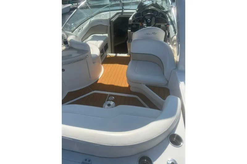 Slide: The Image of 2008 Sea Ray 220 Sundancer boat interior with white seating and wood flooring. - 18