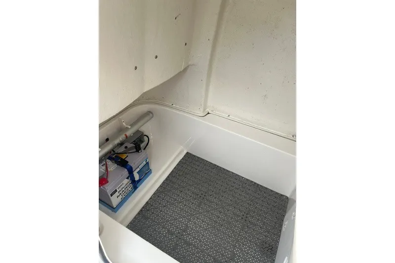 Slide: The Image of 2023 Sea Fox 248 Commander storage compartment with battery and non-slip mat. - 27