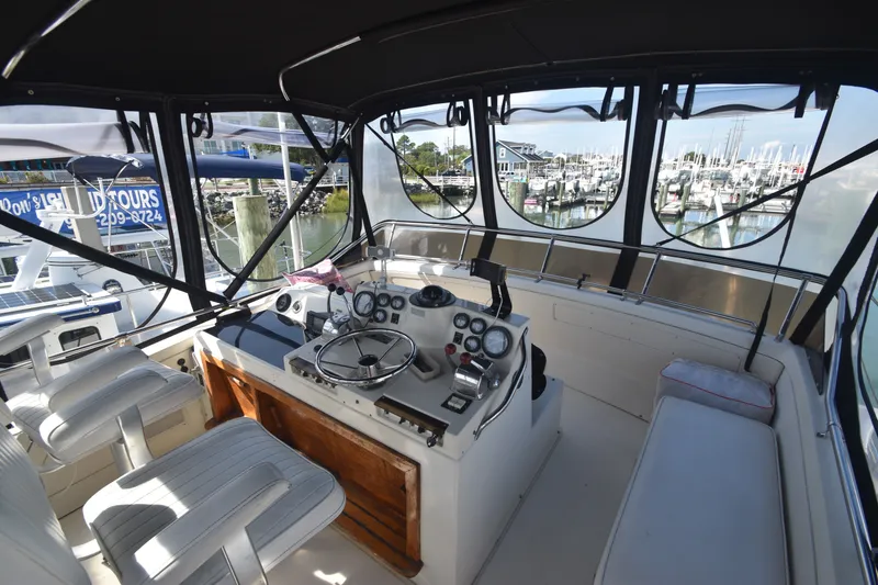 Slide: The Image of The image shows the helm of a 1981 Viking 43 Aft Cabin with a view of a marina. - 37