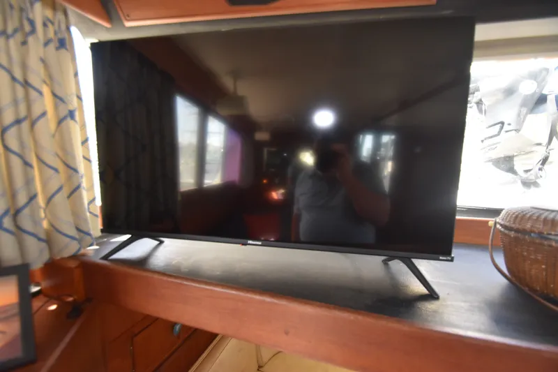 Slide: The Image of A modern TV sits on a wooden table in a boat cabin. - 34