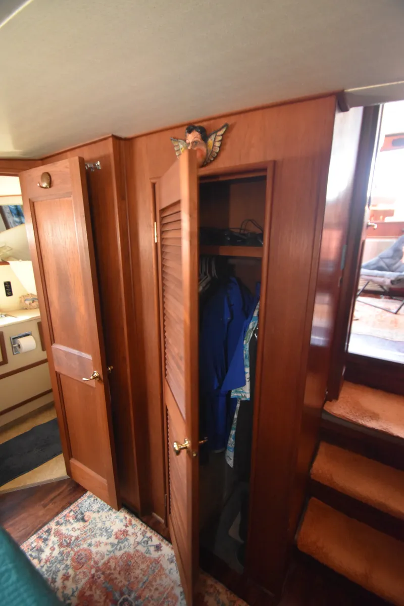 Slide: The Image of Wooden closet with clothes inside, next to stairs in a boat cabin. - 30