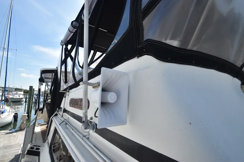 Slide: The Image of A 1981 Viking 43 Aft Cabin with a speaker and black canopy, docked at a marina. - 47