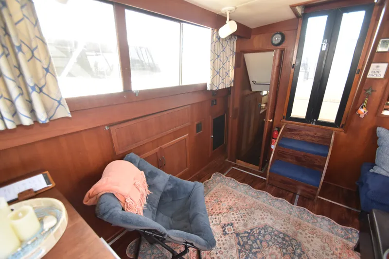 Slide: The Image of Interior of a 1981 Viking 43 Aft Cabin with wood paneling, carpet, and cozy seating. - 16