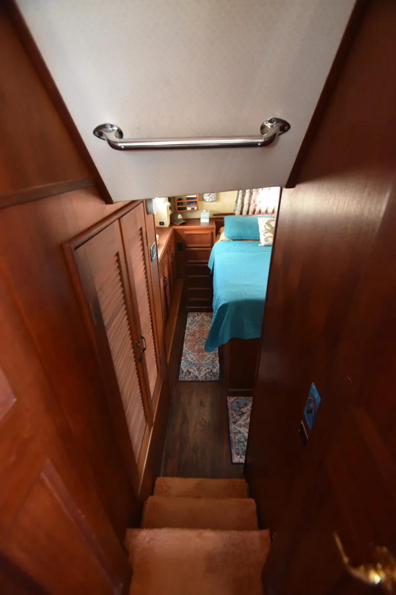 Slide: The Image of Interior of a 1981 Viking 43 Aft Cabin with wood paneling and a bed with a blue cover. - 22