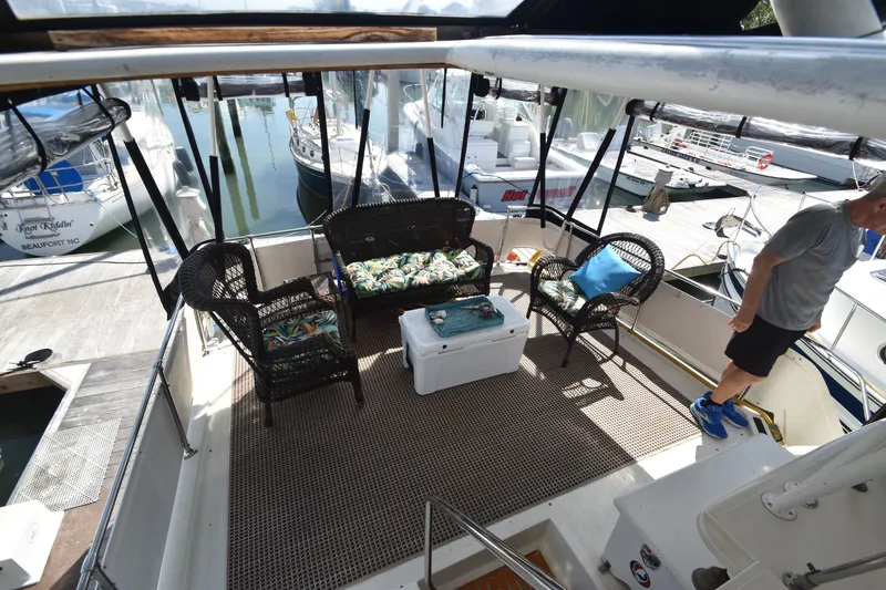 Slide: The Image of The image shows the aft deck of a 1981 Viking 43 Aft Cabin with wicker furniture and a cooler. - 43