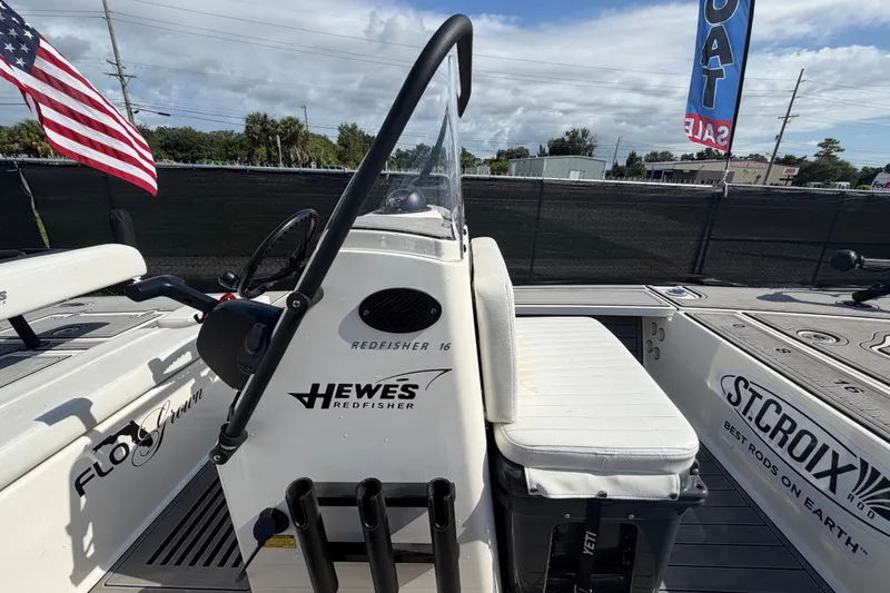 Slide: The Image of 2022 Hewes Redfisher 16 boat with American flag, displayed at a sales event. - 41
