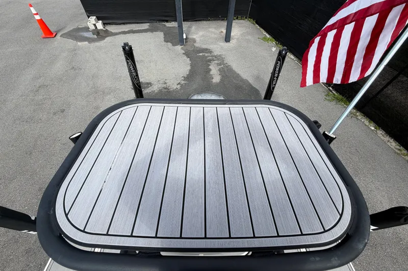 Slide: The Image of 2022 Hewes Redfisher 16 boat platform with American flag and pavement background. - 58