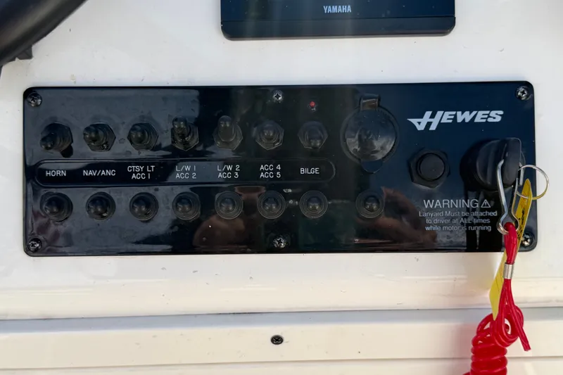 Slide: The Image of Control panel of a 2022 Hewes Redfisher 16 boat with switches and warning label. - 21