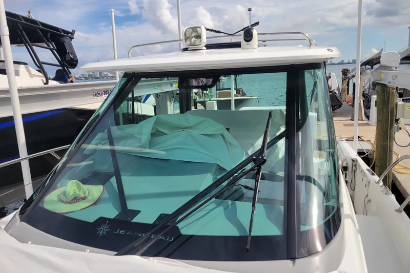 Slide: The Image of 2025 Jeanneau Leader 10.5 WA Series 2 boat docked, featuring a covered cockpit and clear windshield. - 12