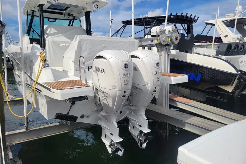 Slide: The Image of 2025 Jeanneau Leader 10.5 WA Series 2 with twin Yamaha outboard engines docked. - 2