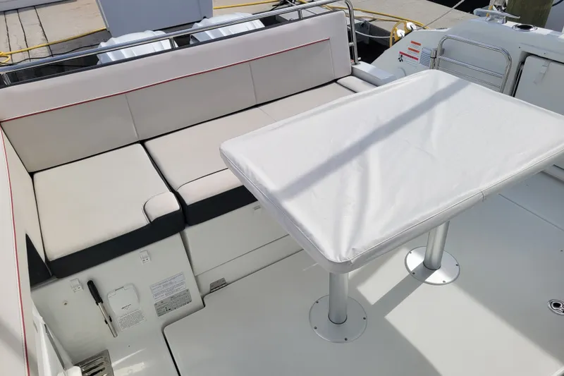 Slide: The Image of 2025 Jeanneau Leader 10.5 WA Series 2 boat interior with cushioned seating and table. - 17