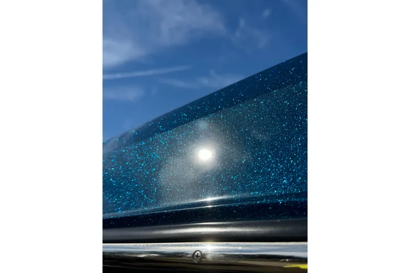 Slide: The Image of Close-up of 2022 Nautique Super Air Nautique S23's sparkling blue exterior under sunlight. - 25