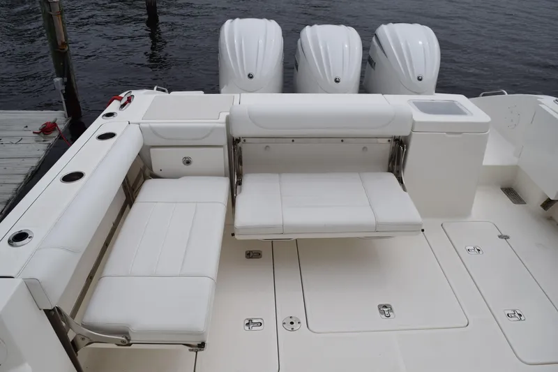 Slide: The Image of 2022 Pursuit OS 355 Offshore boat with white seating and triple outboard engines. - 50