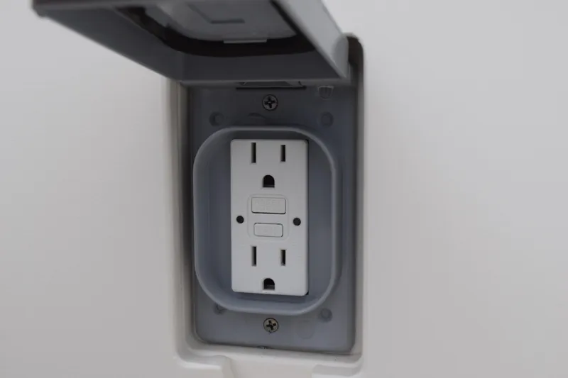 Slide: The Image of GFCI outlet on 2022 Pursuit OS 355 Offshore boat, with protective cover open. - 41