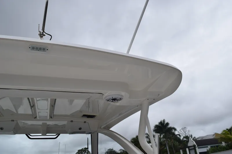Slide: The Image of 2022 Pursuit OS 355 Offshore boat roof with antenna and speaker, under cloudy sky. - 19