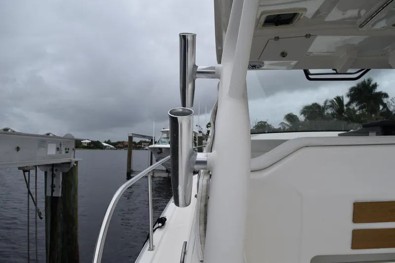 Slide: The Image of 2022 Pursuit OS 355 Offshore boat docked, featuring stainless steel rod holders. - 152