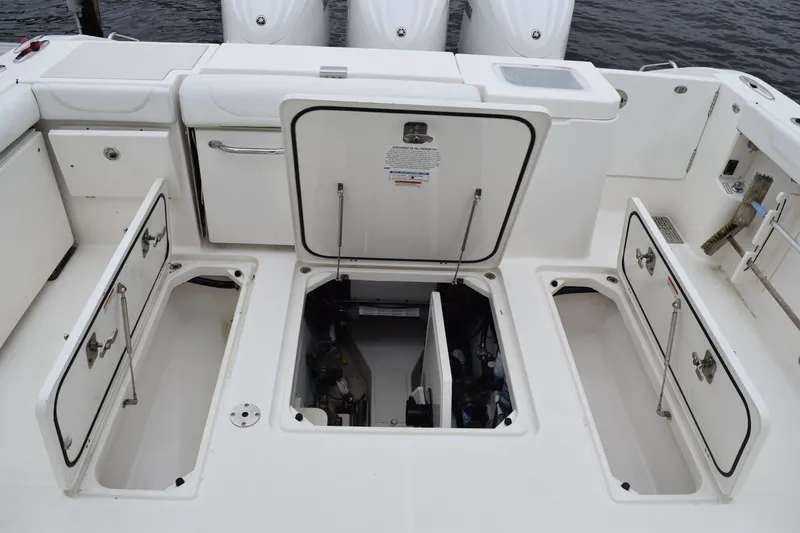 Slide: The Image of 2022 Pursuit OS 355 Offshore boat deck with open storage compartments and engine access. - 145