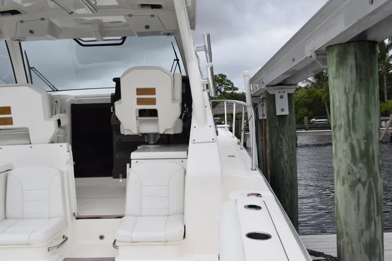 Slide: The Image of 2022 Pursuit OS 355 Offshore boat docked, featuring white seating and sleek design. - 98