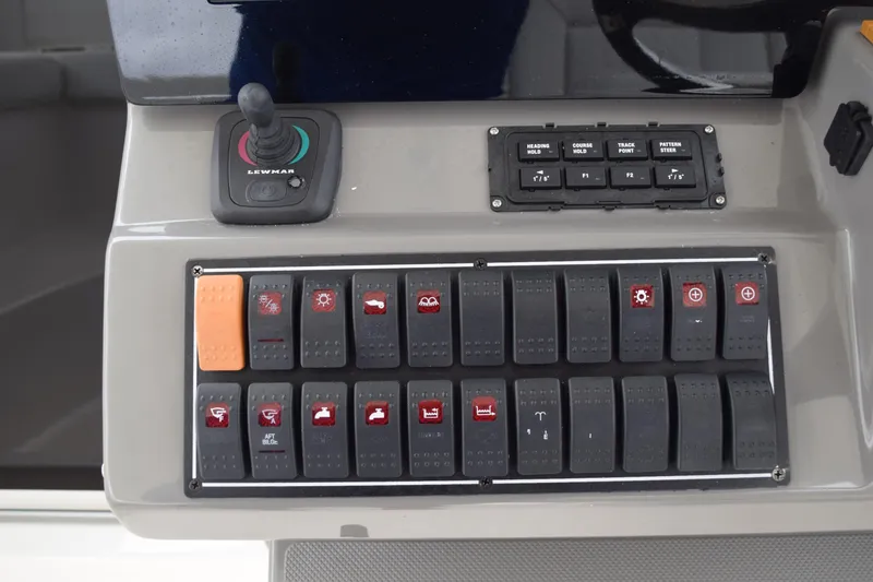 Slide: The Image of Control panel of 2022 Pursuit OS 355 Offshore boat with switches and joystick. - 273