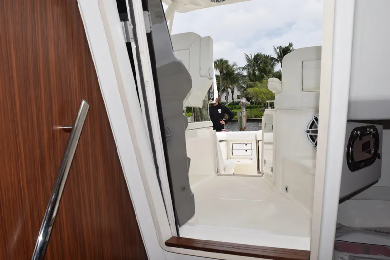 Slide: The Image of 2022 Pursuit OS 355 Offshore boat interior with open door, dockside view. - 338