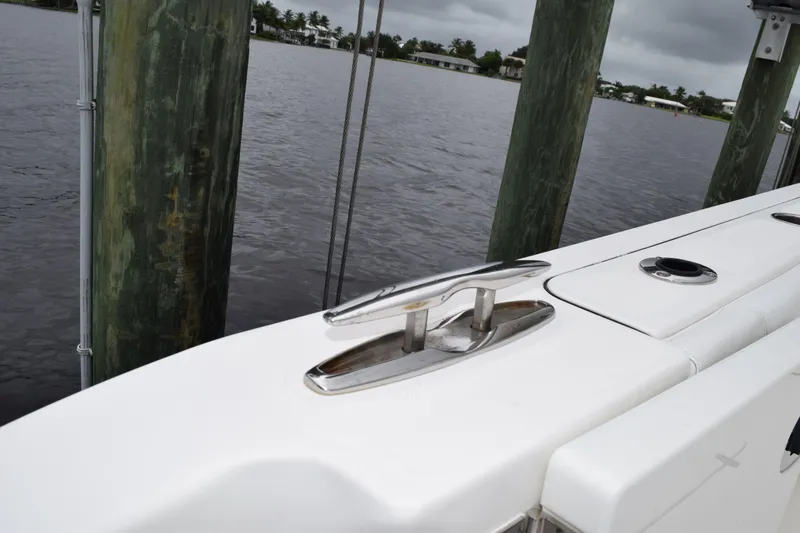 Slide: The Image of 2022 Pursuit OS 355 Offshore boat docked by wooden pilings on a cloudy day. - 80