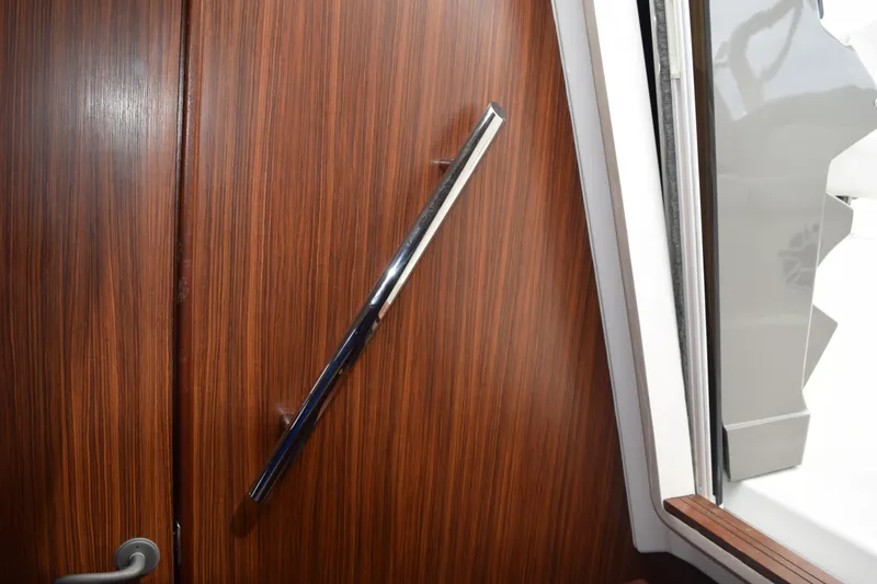 Slide: The Image of 2022 Pursuit OS 355 Offshore interior with wooden paneling and chrome handle. - 340