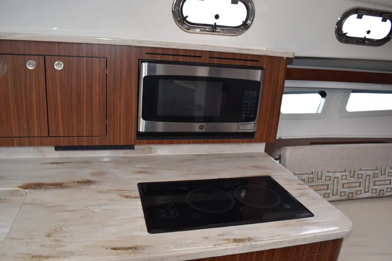 Slide: The Image of 2022 Pursuit OS 355 Offshore yacht kitchen with microwave and stovetop. - 385