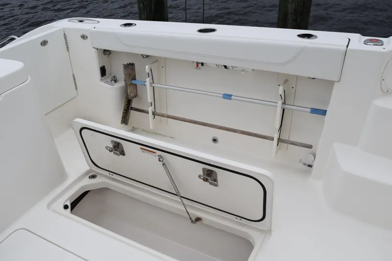 Slide: The Image of 2022 Pursuit OS 355 Offshore boat storage compartment with cleaning tools. - 122