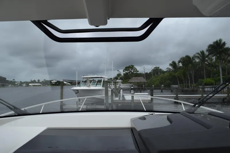 Slide: The Image of 2022 Pursuit OS 355 Offshore boat docked at marina, overcast sky, palm trees in background. - 208