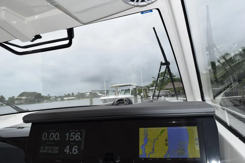 Slide: The Image of 2022 Pursuit OS 355 Offshore boat dashboard with navigation display, docked in a marina. - 304
