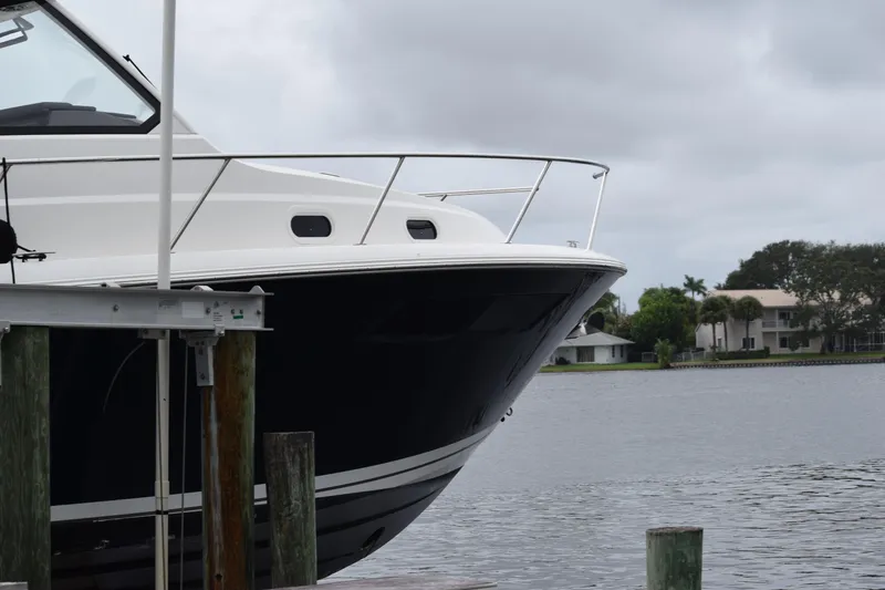 Slide: The Image of 2022 Pursuit OS 355 Offshore boat docked by a serene waterfront. - 459