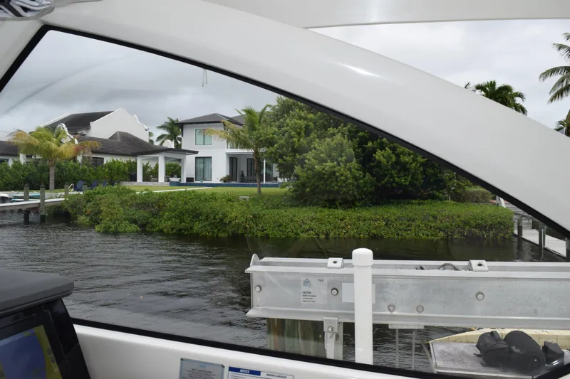 Slide: The Image of 2022 Pursuit OS 355 Offshore boat view, overlooking waterfront property with lush greenery. - 210