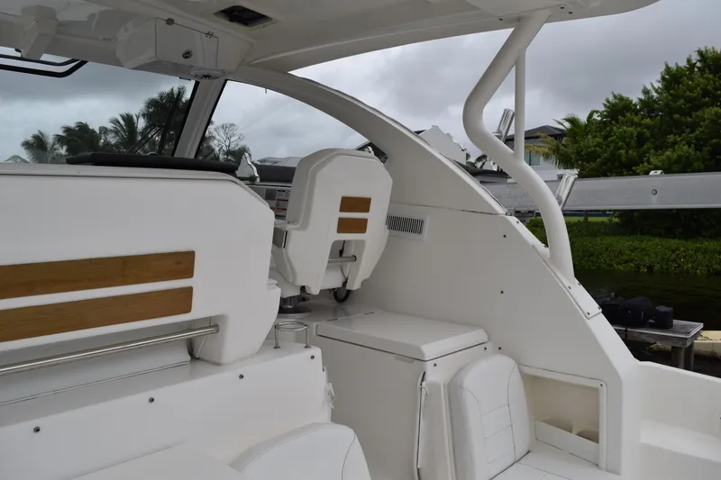Slide: The Image of 2022 Pursuit OS 355 Offshore boat interior with white seating and wooden accents. - 159