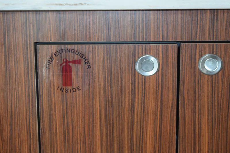 Slide: The Image of Wooden cabinet on 2022 Pursuit OS 355 Offshore with fire extinguisher sign. - 390