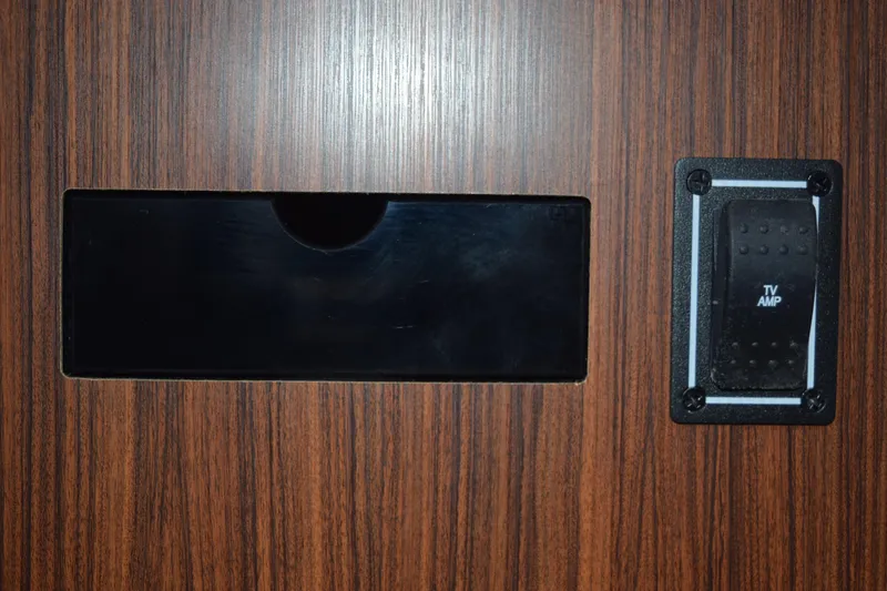 Slide: The Image of Wood panel with TV amp switch on 2022 Pursuit OS 355 Offshore boat. - 404
