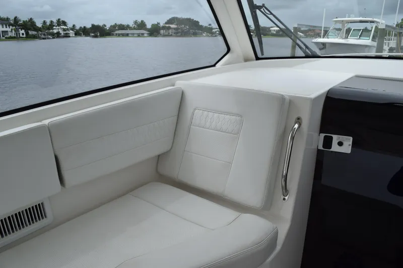 Slide: The Image of Interior of 2022 Pursuit OS 355 Offshore boat with white seating and lake view. - 241