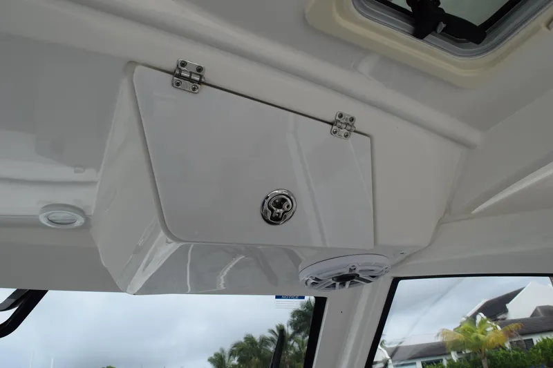 Slide: The Image of 2022 Pursuit OS 355 Offshore interior storage compartment with speaker and window view. - 221