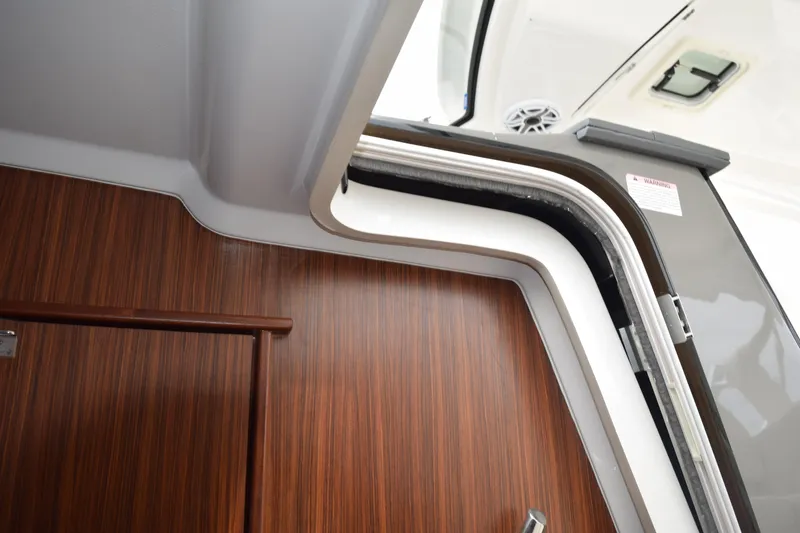 Slide: The Image of Interior view of 2022 Pursuit OS 355 Offshore boat, featuring wood paneling and open hatch. - 341