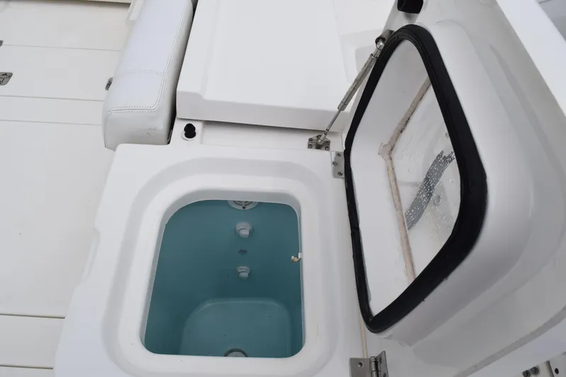 Slide: The Image of 2022 Pursuit OS 355 Offshore boat with open storage compartment and cushioned seating. - 61