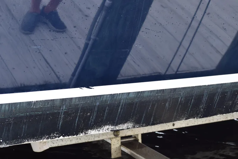 Slide: The Image of 2022 Pursuit OS 355 Offshore boat hull with visible wear and reflection. - 448